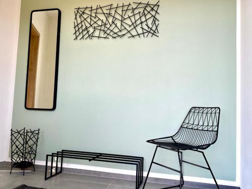 a black chair sitting next to a wall with a mirror at Gästehaus Bayreuth in Bayreuth