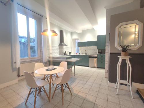 une cuisine avec une table et des chaises dans une pièce dans l'établissement Le Chartrand- Centre-ville- Séjour inoubliable!, à Carcassonne
