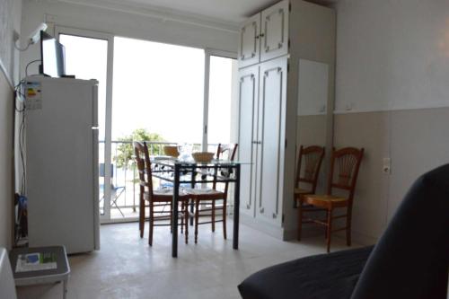 un salon avec une table et des chaises et une cuisine dans l'établissement NP370-005 Appartement Studio, Narbonne Plage, à Narbonne-Plage