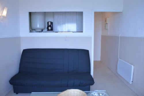 une chaise bleue assise dans une pièce avec une table dans l'établissement NP370-005 Appartement Studio, Narbonne Plage, à Narbonne-Plage