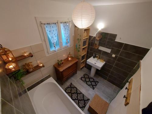vista sul soffitto di un bagno con vasca e lavandino di Chambre dans grande maison paisible a Paulhan