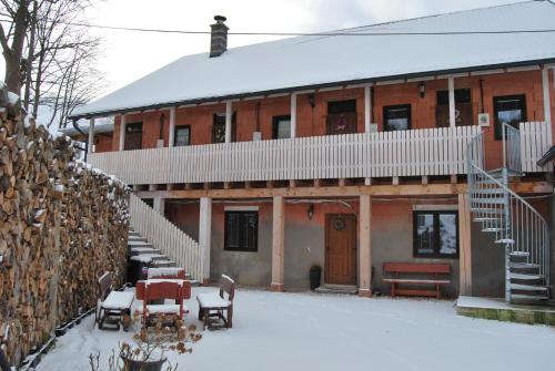 a building with a table and chairs in the snow at Apartmán Levandule in Mařenice