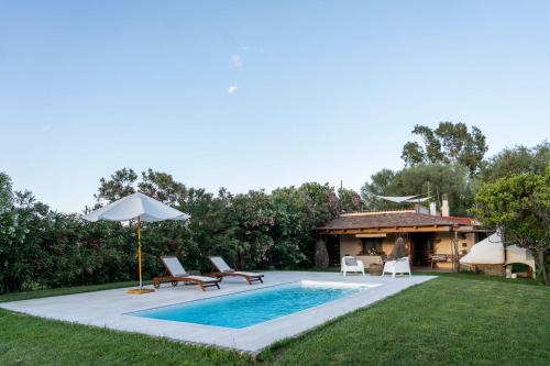 a pool with chairs and an umbrella and a house at Casa Nurru in Orosei
