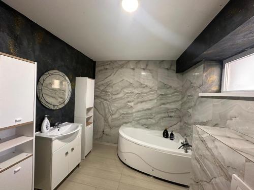a bathroom with a tub and a sink and a bath tub at Cabana Ursu in Iaşi