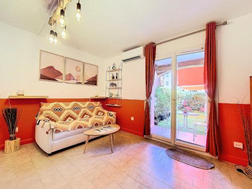 un salon avec un canapé et une table dans l'établissement Cosy, Wi-Fi, jardin & parking, Jasmins Studio entre Cannes et Antibes, à Vallauris