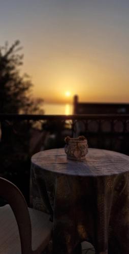a table with a crown on it with the sunset in the background at B&B La Rosa dei Venti Palinuro in Palinuro