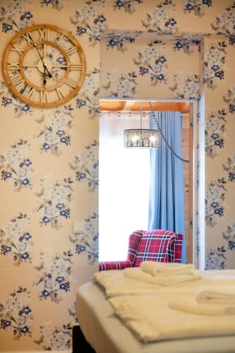 a bedroom with a clock on the wall at Design Hotel ALPENLIEBE - - - - Boutique-Flair - - - - in Inzell