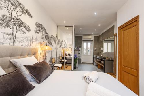 une chambre avec un lit blanc et une salle de bain dans l'établissement L'ÉCLAT, Méditerranéen - Hypercentre, Rue piétonne, à Menton