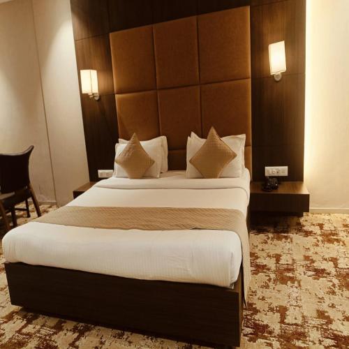 a bedroom with a large bed in a hotel room at Raj Regency in Vilad