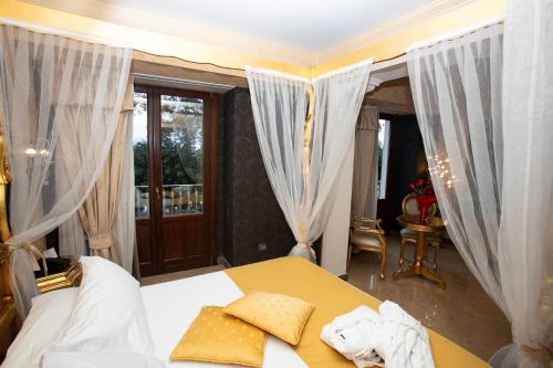 a bedroom with a bed with curtains and a balcony at Hotel Il Principe in Milazzo