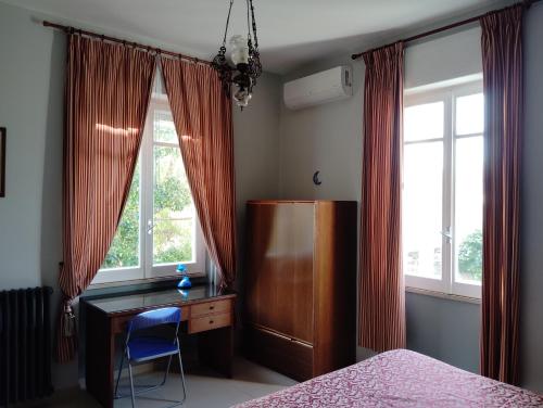 a bedroom with a desk and a bed and windows at Short Lets Pescara in Pescara
