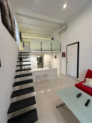 - un escalier dans le salon doté d'un canapé rouge dans l'établissement LOFT vieille ville Cannes proximité plage et palais des festivals, à Cannes