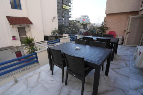 a black table and chairs on a balcony at Enles Hotel in Durrës