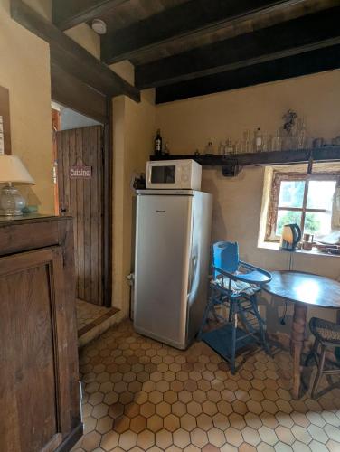 Il comprend une cuisine équipée d'un réfrigérateur et d'une table avec un four micro-ondes. dans l'établissement ferme de la gortiere, à Le Teilleul