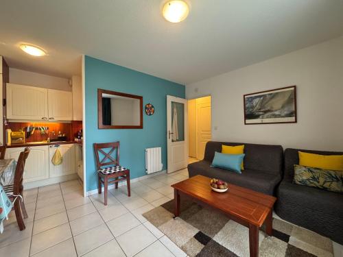 un salon avec un canapé et une table dans l'établissement Azur Marin - Wifi, Parking, Piscine, Mer à 2min, à Pornichet