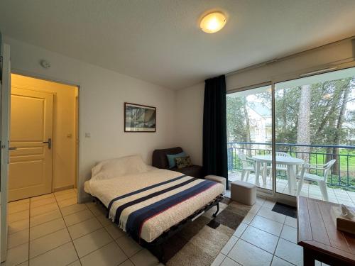 une chambre avec un lit et un balcon avec une table dans l'établissement Azur Marin - Wifi, Parking, Piscine, Mer à 2min, à Pornichet