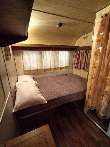 a small bed in the back of an rv at Camping Roma in Ventimiglia