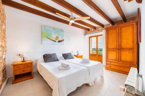 a bedroom with two beds and a window at Can Pascual Gran in Manacor