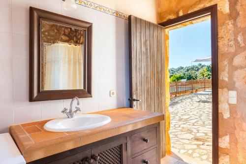 a bathroom with a sink and a door to a patio at Can Pascual Gran in Manacor