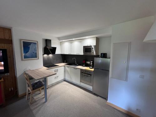 une petite cuisine avec une table et un réfrigérateur dans l'établissement Charmant logement avec Balnéo - La Plagne 1800, à Plagne 1800