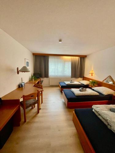 a room with four beds and a desk in it at Schwanstetten bei Nürnberg, gemütliches Apartment mit Küche Bad TV in Schwanstetten