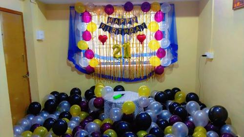 a room with a bunch of balloons and a happy birthday balloon wall at Royal Home Stay Honnavar in Kāsarkod