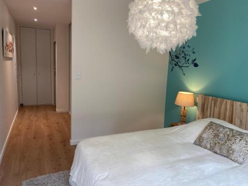 a bedroom with a white bed and a chandelier at Villa du Golf in Baden