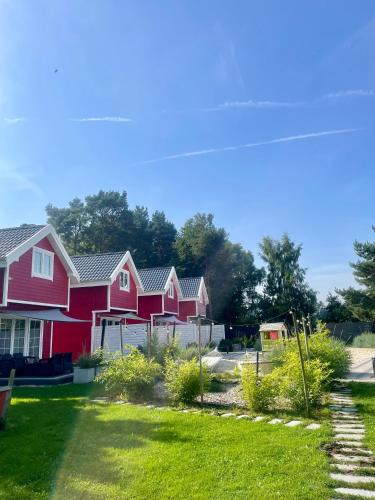 a row of red houses in a yard at Czerwone Domki in Dębki