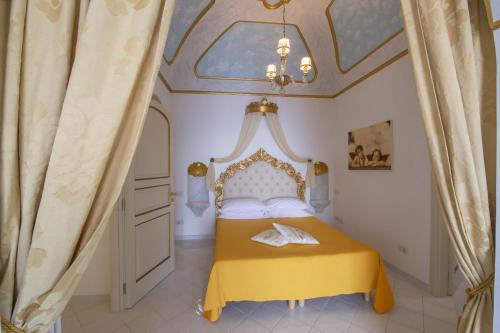 a bedroom with a yellow bed with a ceiling at Luxury Villa Soleluna con jacuzzi in Praiano