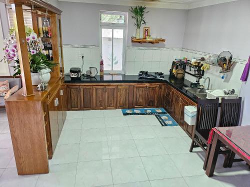 a kitchen with wooden cabinets and a tile floor at Bắp's House Đà Lạt in Da Lat