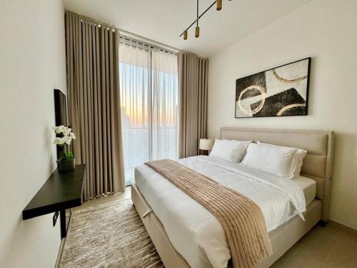 a bedroom with a bed and a desk and a window at Elegant 1br Apt In Jvc With Spacious Balcony in Dubai