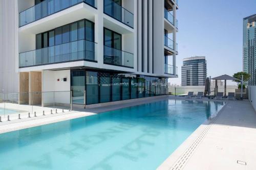 a swimming pool in front of a building at Elegant 1br Apt In Jvc With Spacious Balcony in Dubai