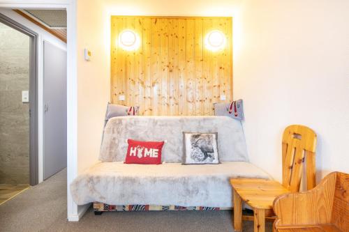 - une chambre avec un lit et un mur en bois dans l'établissement Aiguilles 501 - Station à 10min à pied, à La Toussuire