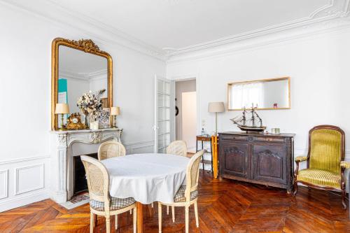 une salle à manger avec une table, des chaises et un miroir dans l'établissement GuestReady- Modern Comfort near Parc Monceau for 6, à Paris