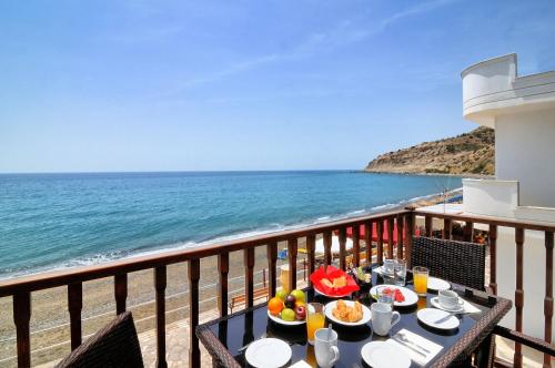 a table with food on a balcony overlooking the ocean at Myrtos Mare Suite Mit Meerblick in Myrtos