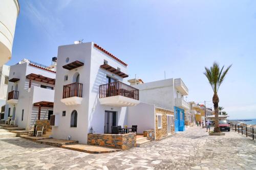 a house on a street with a palm tree at Myrtos Mare Suite Mit Meerblick in Myrtos