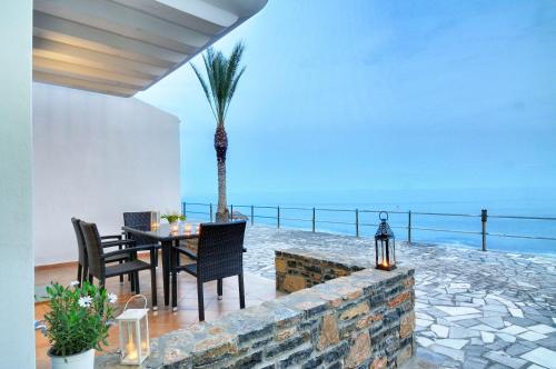 a dining room with a table and a palm tree at Myrtos Mare Suite Mit Meerblick in Myrtos