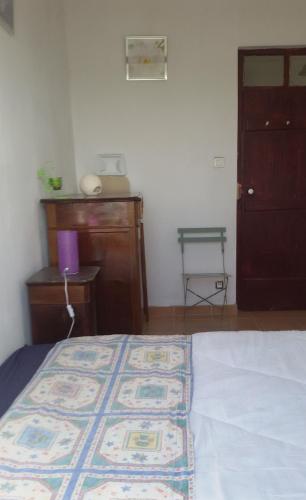 a bedroom with a bed and a dresser and a door at Ferienhaus In Coimbrão Mit Eigenem Pool in Coimbrão