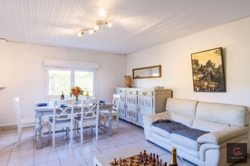 un salon avec un canapé et une table dans l'établissement Biscarrosse Lac - A deux pas du lac maison avec jardin pour 6 personnes, à Biscarrosse
