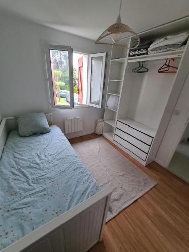 - une petite chambre avec un lit et un placard dans l'établissement Socoa- 2 chambres- Proche Plage, à Urrugne