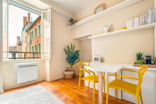 une salle à manger avec une table et des chaises et une fenêtre dans l'établissement Hammac Suites - Capucins, à Lyon