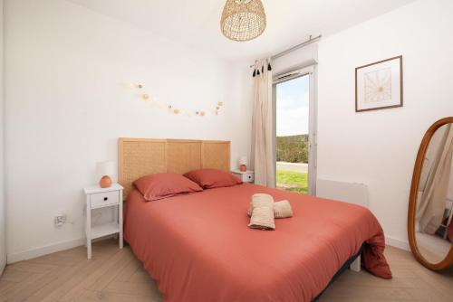 a bedroom with a bed with orange sheets and a mirror at Joli T2 avec terrasse et Parking in Toulouse