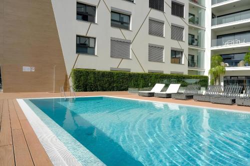 a swimming pool in front of a building at São Lucas apartamento com piscina e parking no Funchal in Funchal