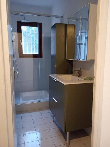 une salle de bain avec une douche, un lavabo et une baignoire dans l'établissement Villa à 500 m de la plage, à Saint-Florent