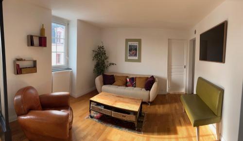 a living room with a couch and a table at L'Ancrage in Saint Malo