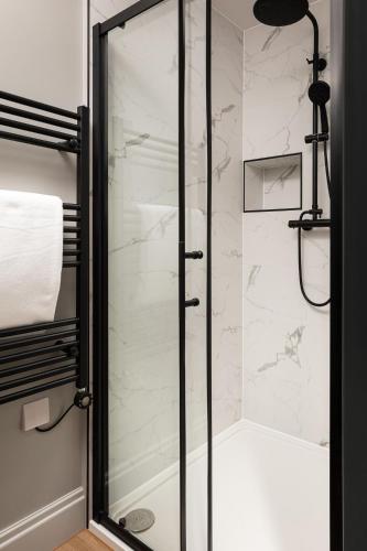 a shower with a glass door in a bathroom at Brayford House Burton Road - stylish accommodation suitable for families and contractors in Lincoln