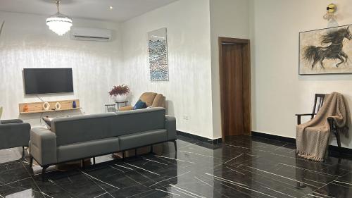 a living room with a couch and a tv at Henlesby Village in Mlichakpo