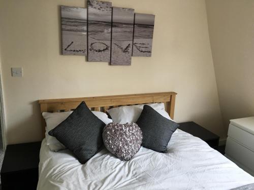 a bedroom with a bed with black and white pillows at Ocean Apartment, 50 yds to Beach, Sleeps 10 in Weymouth
