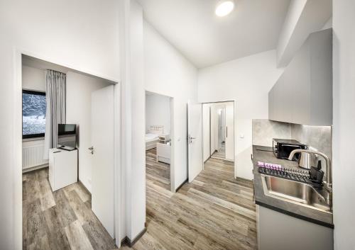 a kitchen with white walls and wooden flooring at Residence Riverside in Pec pod Sněžkou
