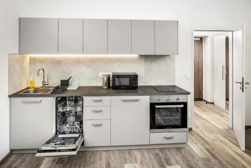 a kitchen with white cabinets and a counter top at Residence Riverside in Pec pod Sněžkou